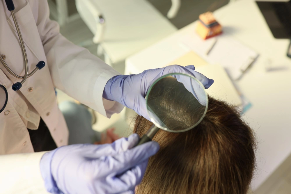 Gros plan sur un médecin trichologue examinant le cuir chevelu d'un patient dans un cabinet médical à des fins de diagnostic